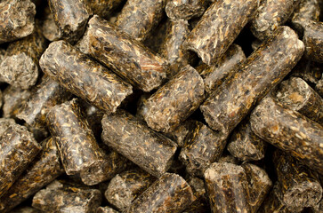 Granulated sunflower feed as a background, close-up, top view. A pile of sunflower meal granules. Pile of animal food pellets, background, top view.