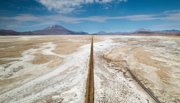 Aerial drone view of train tracks on Uyuni desert, the biggest salt desert in the world, Uyuni, Bolivia.