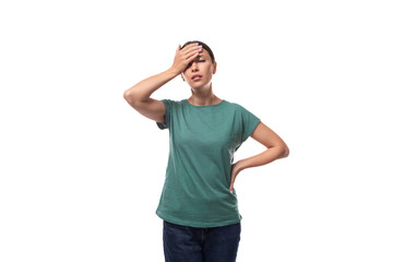 young forgetful brunette woman dressed in a green t-shirt on a white background