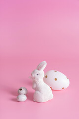 White rabbit and eggs symbol for Easter on a pink background background