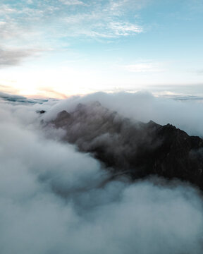 View of mountain peaks and low hanging clouds during sunrise, near Pico de Areeiro, Madeira Island, Portugal.