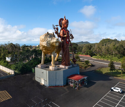 Aerial drone view of the gigantic statue of Hindu goddess Durga Maa Bhavani with golden lion overlooking the entrance of the holy site, Grand Bassin, Savanne, Mauritius.