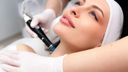 Hydrofacial procedure on the face of a young woman in a professional beauty clinic. Facial care and...