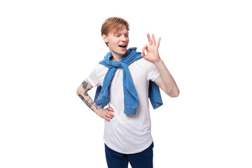 young cute caucasian guy with short red hair with a tattoo on his arms actively gesturing