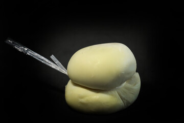 White Italian scamorza on a black background
