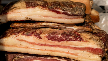 Large pieces of smoked lard with meat close-up on a market counter