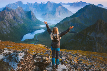 Woman tourist traveling in Norway alone enjoying aerial mountain view hiking in mountains outdoor female solo traveler raised hands healthy lifestyle adventure vacations exploring Lofoten islands - 741697563