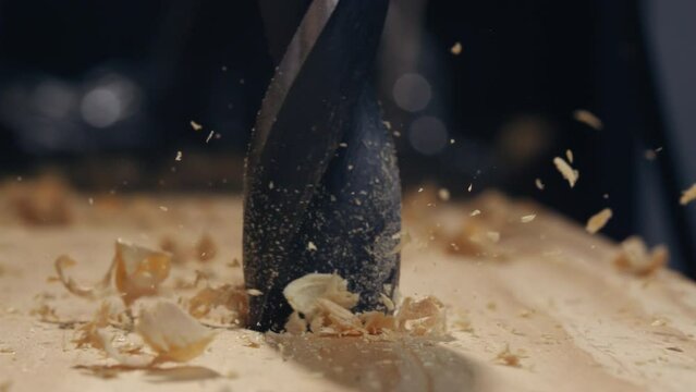 Witness the mesmerizing precision of a drill as it bores through wood in slow motion, showcasing the artistry of woodworking.