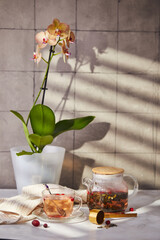 Fruits and berries tea. Glass teapot and cup on the table