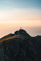 Man backpacker standing on mountain summit alone active travel in Norway hiking outdoor healthy lifestyle adventure vacations exploring Lofoten islands climbing expedition eco tourism - 741699586