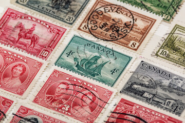 Ukraine, Kiyiv - February 3, 2024.Postage stamps from Canada.Collection  vintageof stamps and magnifying glass.Postage stamps from different countries and times - obrazy, fototapety, plakaty