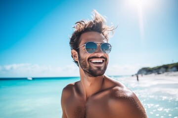 Portrait of young handsome man in sunglasses on the tropical beach.