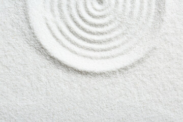 Fototapeta na wymiar Zen rock garden. Circle pattern on white sand, top view. Space for text