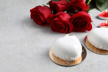 St. Valentine's Day. Delicious heart shaped cakes and roses on light table. Space for text