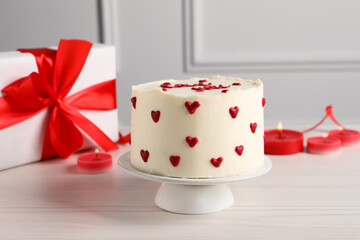Bento cake, candles and gift box on white wooden table. St. Valentine's day surprise
