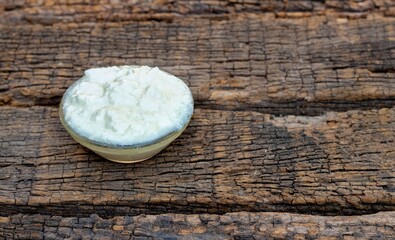 Homemade Dahi or Curd in a Glass Bowl Isolated on Textured Wooden Background with Copy Space