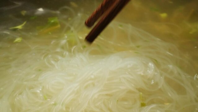 Cooking instant Funchoza noodles texture.noodles in boiling water with spices close-up. Asian fast food. Instant noodles, or instant ramen, is a type of food consisting of noodles sold in a precooked