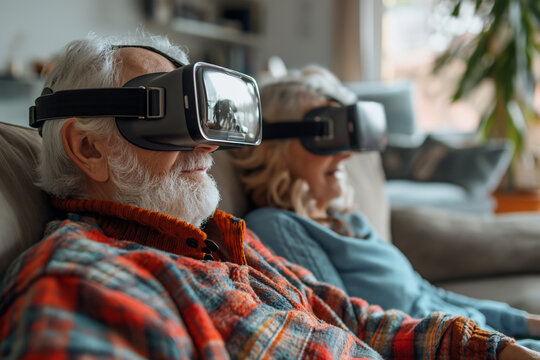 Senior man with woman wearing virtual reality glasses sitting on sofa