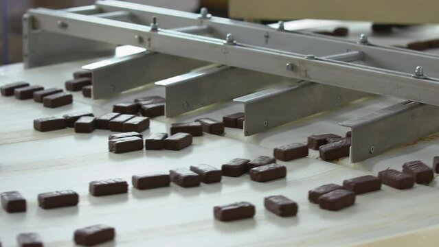 Conveyor belt with chocolate candy bars. Production line in chocolate factory.