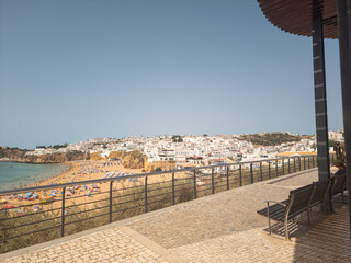 Scenic view of a coastal town with white buildings, beachfront, and clear skies, as seen from a...
