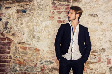 Handsome young man against brick wall