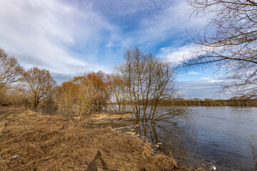 early spring flood, high water in the countryside, river overflowing its banks, trees in the water, flooded banks, environmental pollution, ecology