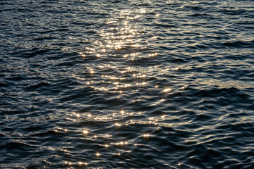 Sunlight glints on the wavy sea.
