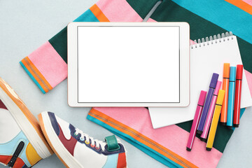 Modern tablet, clothes and stationery on light background, flat lay. Space for text