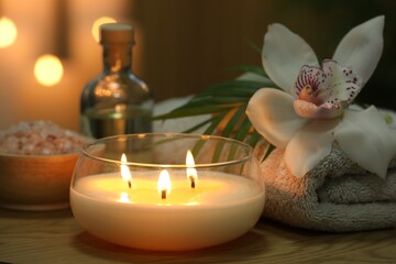 Fototapeta na wymiar Beautiful spa composition with burning candle on wooden table, closeup