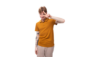 portrait of a young adorable redhead man dressed in a yellow t-shirt on a white background with copy space