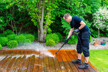 man cleaning terrace with a power washer - high water pressure cleaner on wooden terrace surface - 741785506