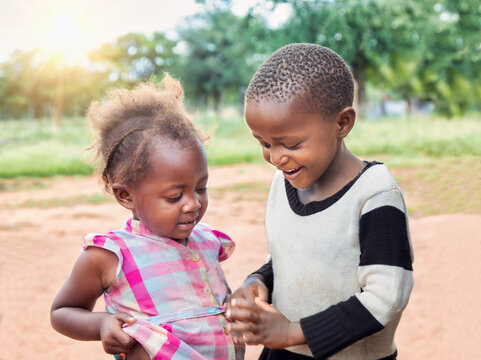 Ngo Volunteer Organizations Around The World Helping African Children. Happy Village Boy And Girl Playing In The Yard.