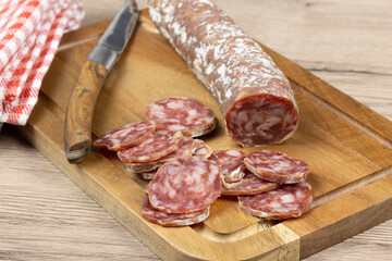 saucisson sec tranché, en gros plan, sur une planche à découper