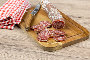 saucisson sec tranché, en gros plan, sur une planche à découper