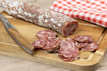 saucisson sec tranché, en gros plan, sur une planche à découper