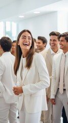 Obraz premium Group of young professionals in white suits networking and laughing at a business event