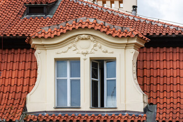 Attic with two rectangular windows on a red tiled roof in the Czech city of Prague. From the series window of the World.