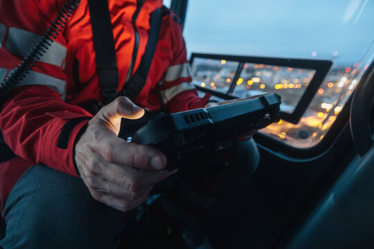 Close-up of hands of doctor inside helicopter emergency medical service while using digital tablet during a night mission flight..