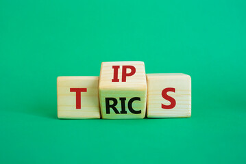 Tips and Tricks symbol. Wooden cubes with words Tricks and Tips. Beautiful green background....