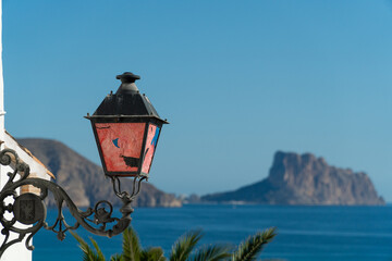 Street lamp with painted glass, with the sea and mountains on the horizon behind, in Altea, Alicante (Spain)