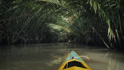 Drift along the tranquil waterways of the Mekong Delta, surrounded by verdant jungle and towering coconut palms, for a peaceful and rejuvenating experience. Near Ben Tre, Vietnam.
