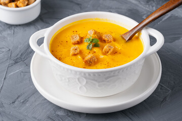 Pumpkin soup with croutons on white background