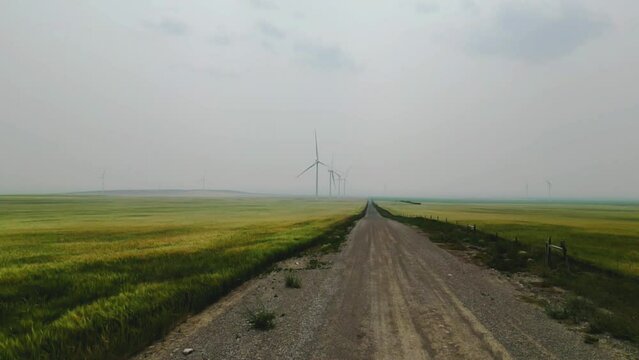 natural landscape in a smoky environment in a wind farm. turbine turning slowly with a low visibility in the air. air quality in Alberta in summer season cause by the wild fire. green house effect