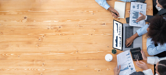 Panorama top view multiracial analyst team use BI dashboard display on laptop screen, analyzing financial data for strategic decision. Fintech analyzes marketing indicators. Concord