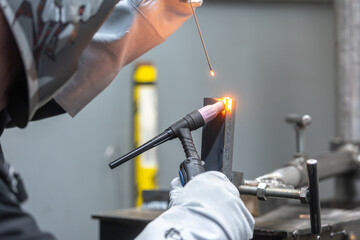 Welder man welding a metal, using a blowtorch, electric arc, or other means, and uniting them by...