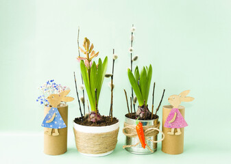 Easter composition on a light background on the table there is an Easter bunny, willow branches and spring hyacinth flowers.  Happy Easter holiday concept.  Space for copying text.  Front view.