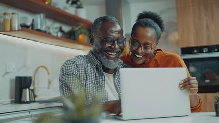 Senior Black Couple Looking At The Laptop With Joy, They Are Inside The Kitchen Of Their Home. Concept Of Good News, Video Calls With Family Or Friends Online. Generative AI