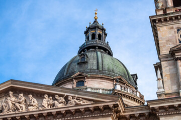 Fototapeta na wymiar St. Stephen Basilica dome rising above old buildings in the city center of Budapest, Hungary with golden cross on the top