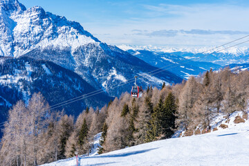 Cable car gondola against snow covered Dolomites in Kronplatz, Italy