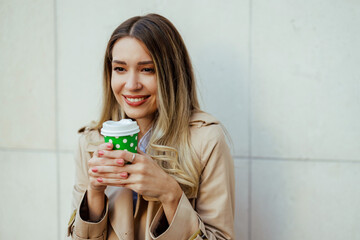 Close up of woman enjoying her coffee to go in urban area.